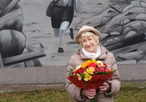 Pani prof. Maria Turowska tuż po odsłonięciu muralu; w tle mural